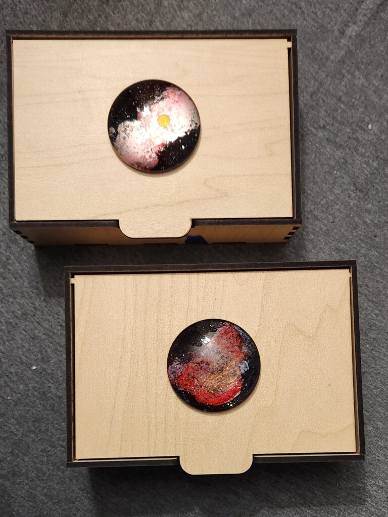 two wooden boxes with round glass space paintings on top